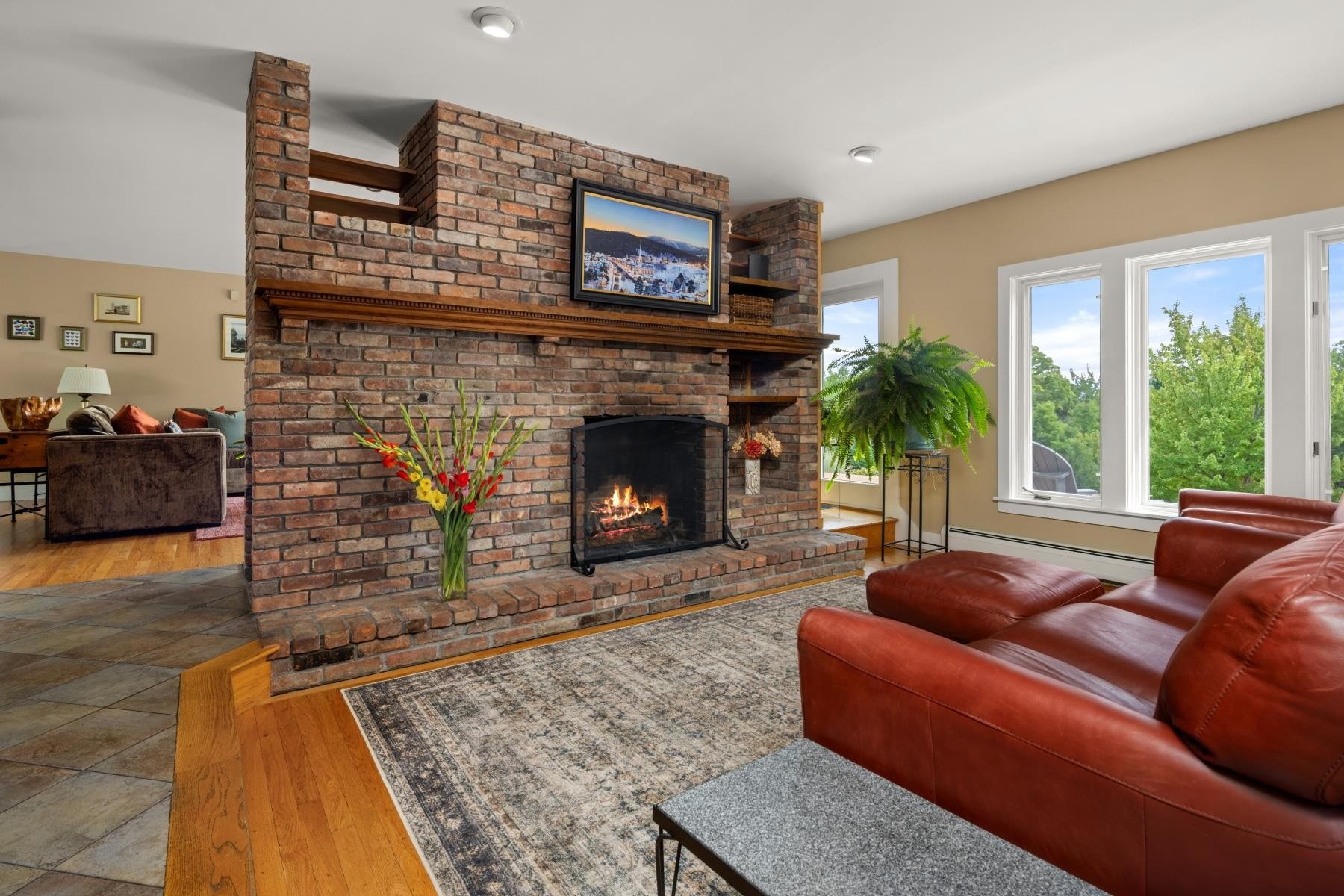 A living room with a fireplace in a Stowe home Pall has listed